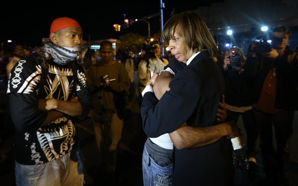 BALTIMORE, MD - APRIL 28:  A protester hugs a woman during a  curfew in Baltimore, Maryland, USA, on 28 April 2015.  Tensions eased on 28 April after demonstrators kept rock-throwing protestors at bay from lines of police in riot gear. Hundreds of people were still out on the street after the 10 pm curfew passed. Police formed a wall against protestors who continued throwing plastic and glass bottles at them and officers threw smoke bombs and shot pepper spray pellets at the protesters. Demonstrations continue over the death of Freddie Gray, 25, an African-American who died on 19 April of injuries suffered in police custody. (Photo by Cem Ozdel/Anadolu Agency/Getty Images)