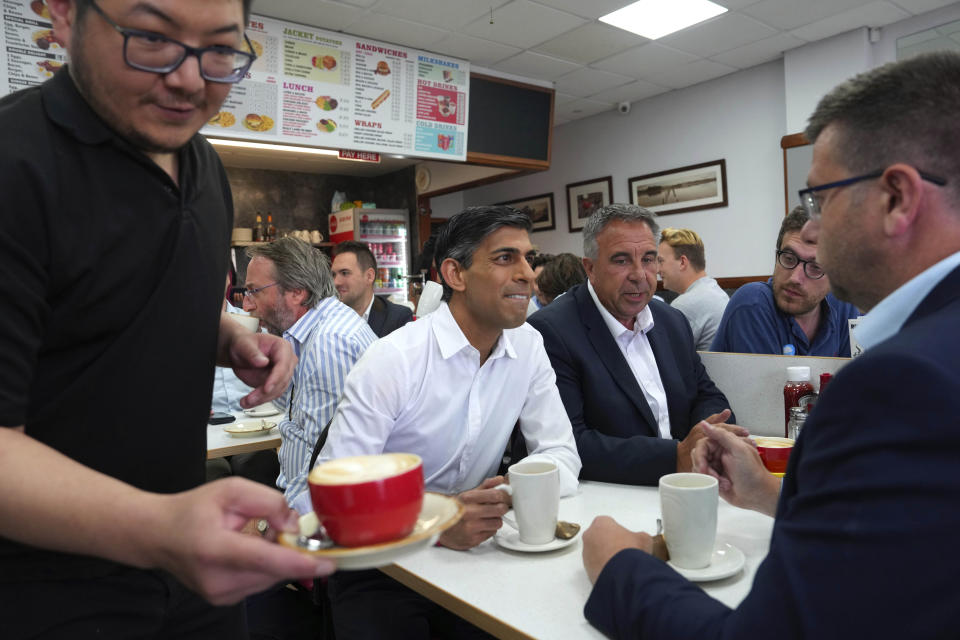 Britain's Prime Minister Rishi Sunak, centre, and newly elected Conservative MP Steve Tuckwell, centre right, speak to party activists at the Rumbling Tum cafe in Uxbridge, after Tuckwell won the Uxbridge and South Ruislip by-election, west London, Friday July 21, 2023. Britain's governing Conservative Party suffered two thumping defeats Friday in a trio of special elections but avoided a drubbing after holding onto former premier Boris Johnson's seat in suburban London. (Carl Court/Pool Photo via AP)