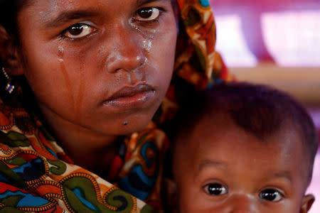 Aisha Begum, a-19 year-old Rohingya refugee, holds her daughter and cries as she tells her story at the camp for widows and orphans inside the Balukhali camp near Cox's Bazar, Bangladesh, December 5, 2017. REUTERS/Damir Sagolj