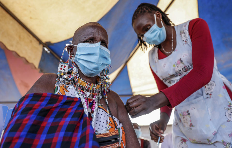 FILE - A Maasai woman receives the AstraZeneca coronavirus vaccine at a clinic in Kimana, southern Kenya on Aug. 28, 2021. The World Health Organization said Thursday, April 14, 2022 that the number of coronavirus cases and deaths in Africa have dropped to their lowest levels since the pandemic began, marking the longest decline yet seen in the disease. (AP Photo/Brian Inganga, File)