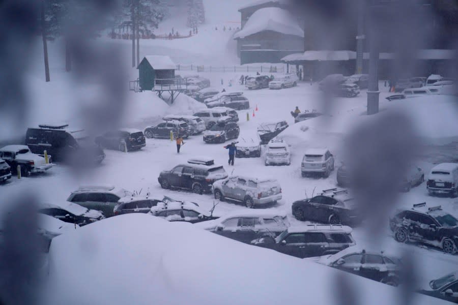FILE – People through the parking area of the Alpine Base Area at Palisades Tahoe during a winter storm Friday, Feb. 24, 2023, in Alpine Meadows, Calif. Search teams were deployed following an avalanche Wednesday at the Palisades ski resort near Lake Tahoe, officials said. (AP Photo/John Locher, File)