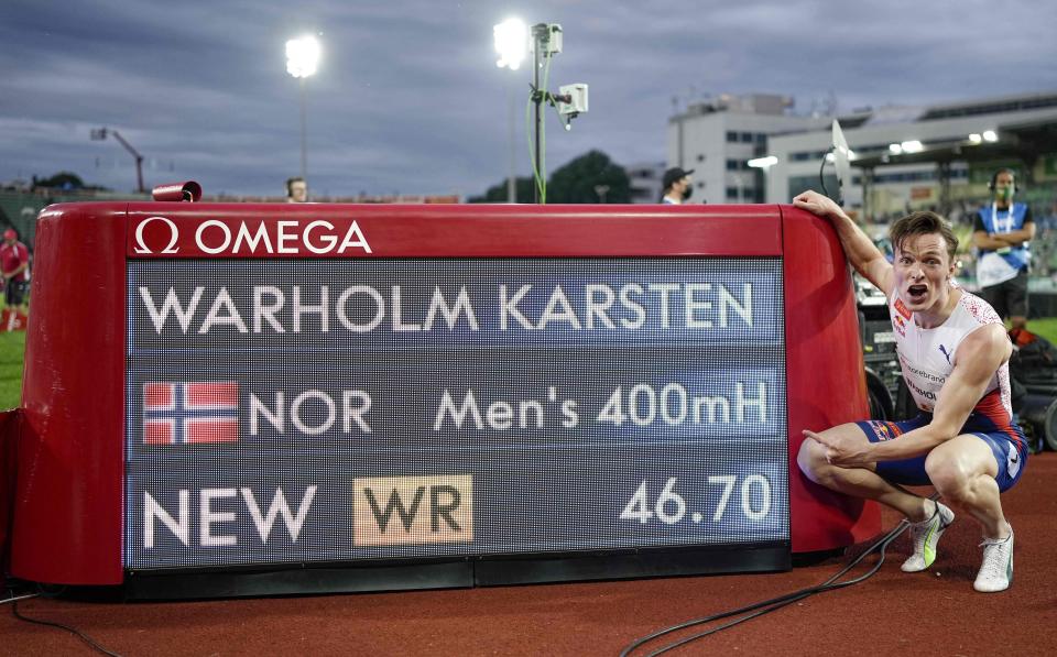 Karsten Warholm in front of a scoreboard showing his new world record for the 400m men's hurdles.