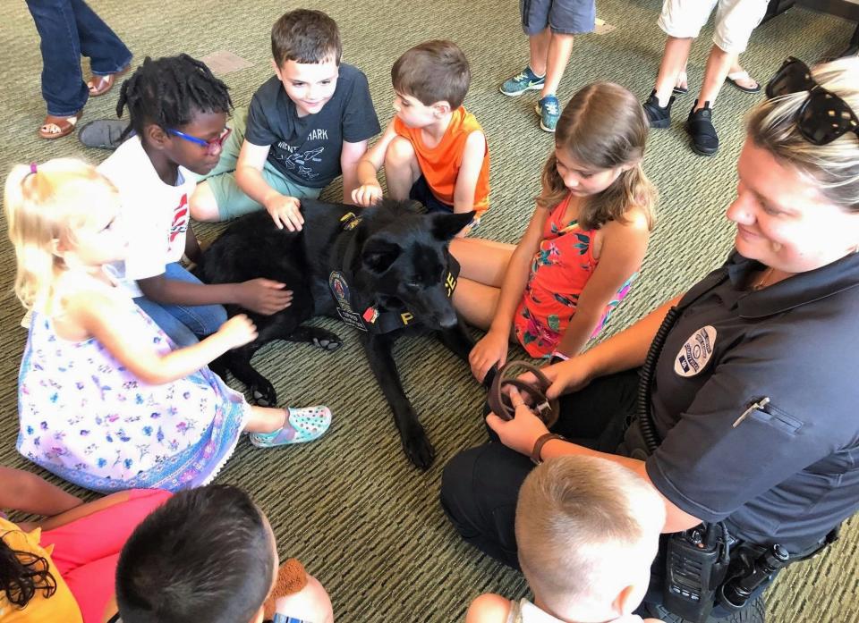 Animal Control Officer Samantha Santilli shares her dog Sansi, a Prince George County Police Department K-9 therapy dog, with children at the Prince George Library in 2019.