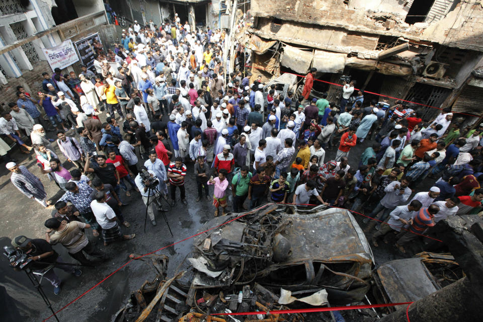 A crowd gathers at the site of a fire that raced through this neighborhood on Wednesday night in Dhaka, Bangladesh, Friday, Feb. 22, 2019. Police on Friday were seeking up to a dozen suspects in connection with a fire in the oldest part of Bangladesh's capital that killed scores of people. (AP Photo/Mahmud Hossain Opu )