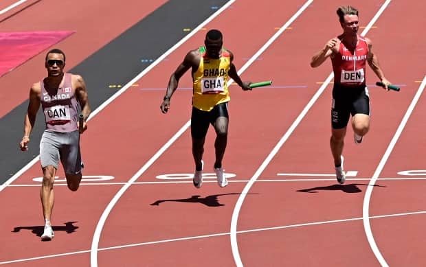 Canada's Andre De Grasse crosses the finish line in second place ahead of Ghana's Joseph Paul Amoah, middle, and Denmark's Frederik Schou Nielsen in the men's 4x100-metre relay heats at the Tokyo Olympics on Thursday in Japan. (Javier Soriano/AFP via Getty Images - image credit)