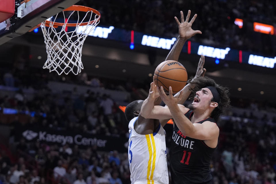 Miami Heat guard Jaime Jaquez Jr. (11) goes up for a shot against Golden State Warriors forward Draymond Green (23) during the first half of an NBA basketball game, Tuesday, March 26, 2024, in Miami. (AP Photo/Wilfredo Lee)