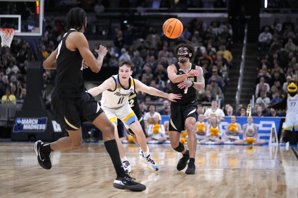 Colorado's J'Vonne Hadley (1) passes to teammate Cody Williams as Marquette's Tyler Kolek (11) defends during the second half of a second-round college basketball game in the NCAA Tournament, Sunday, March 24, 2024 in Indianapolis. (AP Photo/Michael Conroy)