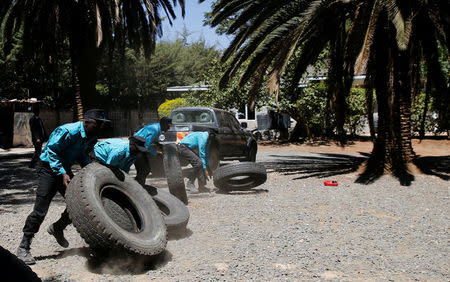 Kenyan security guards participate in physical exercise during a martial arts combat system training at the Chinese-run Deway Security Group compound in Kenya's capital Nairobi, March 13, 2017. REUTERS/Thomas Mukoya