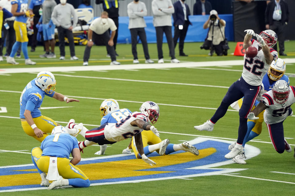 New England Patriots defensive back Cody Davis (22) blocks a field goal attempt from Los Angeles Chargers kicker Mike Badgley, left, during the first half of an NFL football game, Sunday, Dec. 6, 2020, in Inglewood, Calif. The ball was recovered by New England's Devin McCourty, bottom center, who returned the ball for a touchdown. (AP Photo/Ashley Landis)