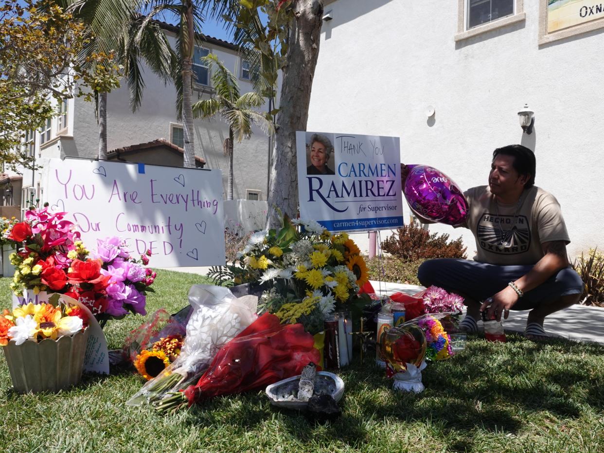 Antonio Delgado, owner of Four Elements Crystal Shop in downtown Oxnard, pays respects to Carmen Ramirez at a sidewalk memorial the day after she was killed crossing a street in August.