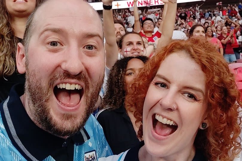 Gus Hully with his wife, Kimberley Robertson, celebrating in a stadium during the Women's Euro in 2022