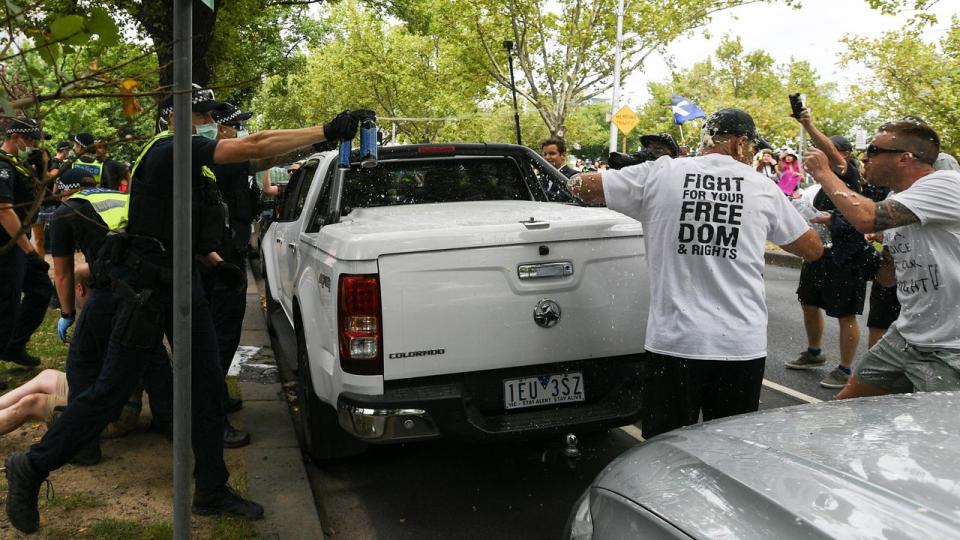 Police deploy pepper spray at a rally in Melbourne in  2021.