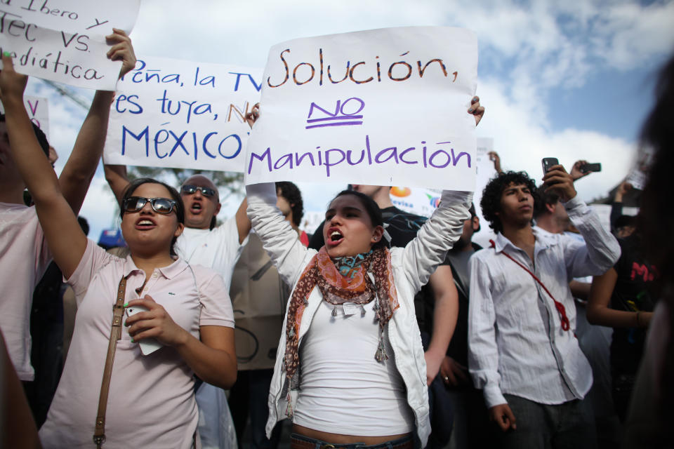 Students shout slogans during a demonstration to protest a possible return of the old ruling Institutional Revolutionary Party (PRI) in Mexico City, Wednesday, May 23, 2012. Demonstrators also protested against what students perceive as a biased coverage by major Mexican TV networks of the presidential elections campaign, which they claim to be directed in favor of PRI's candidate Enrique Pena Nieto. Mexico will hold presidential elections on July 1. (AP Photo/Alexandre Meneghini)