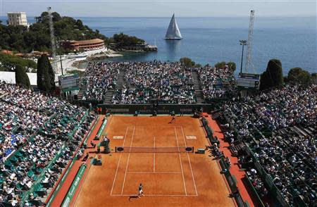 A sail boat passes by the central court as Roger Federer of Switzerland (bottom) prepares to serve against Lukas Rosol of the Czech Republic during the Monte Carlo Masters in Monaco April 17, 2014. REUTERS/Eric Gaillard