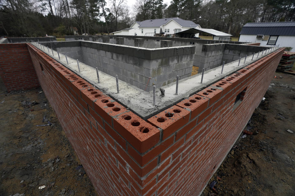 A home in Princeville, N.C., is in the process of having the foundation raised Thursday, March 10, 2022. Flooding from past hurricanes has left permanent damage to the vulnerable community along the Tar River. Some residents have received funding to help rebuild homes and raise foundations. (AP Photo/Gerry Broome)