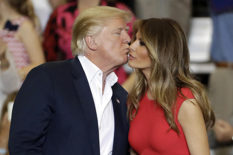 FILE- In this Feb. 18, 2017 file photo, President Donald Trump kisses his wife, first lady, Melania Trump after a campaign rally in Melbourne, Fla. (AP Photo/Chris O'Meara)
