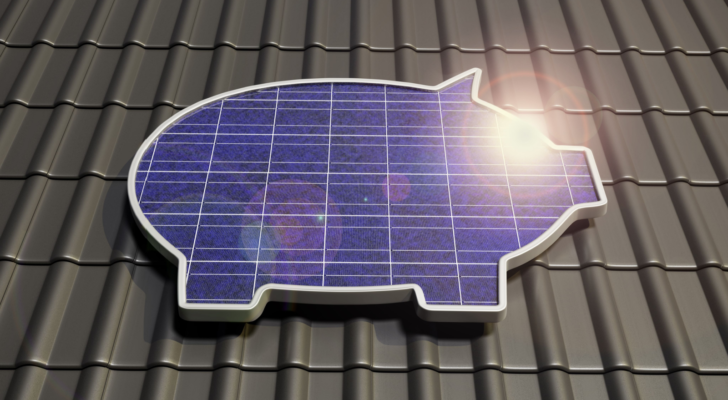 An image of a solar panel in the shape of a piggy bank on a rooftop; concept for solar stocks