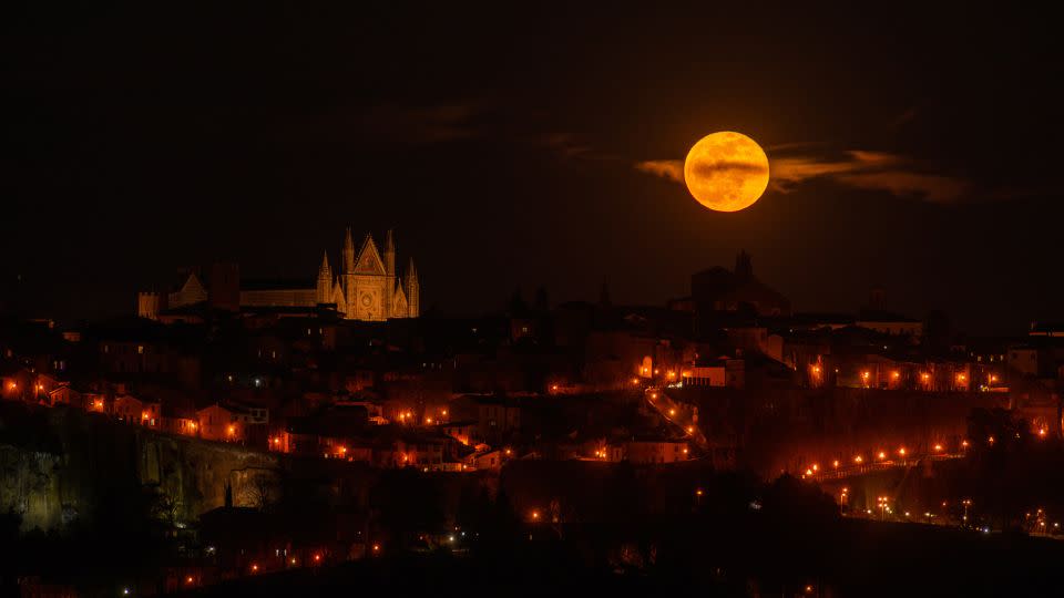 Der rosafarbene Mond geht am 6. April 2023 neben der Kathedrale von Orvieto in der italienischen Region Umbrien auf. In diesem Jahr erreicht der April-Vollmond am Dienstag seinen Höhepunkt.  -Lorenzo Di Cola/NurPhoto/Getty Images