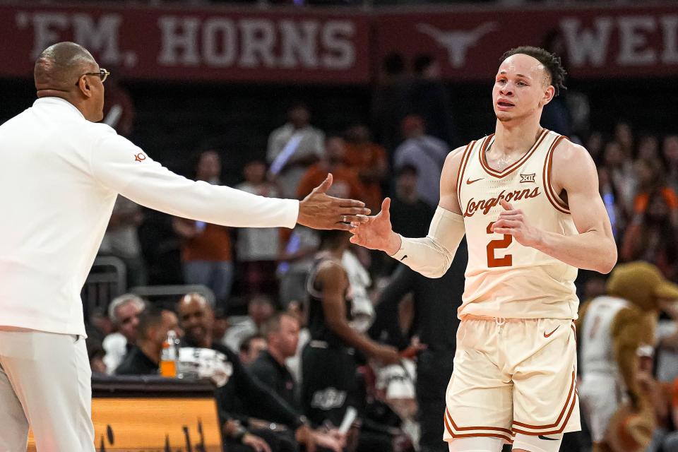 Texas head coach Rodney Terry congratulates guard Chendall Weaver as he exits Saturday's game against Oklahoma State. “I’m a little biased,” Terry said, “but Chendall, without question, has come in and put his mark on every game."