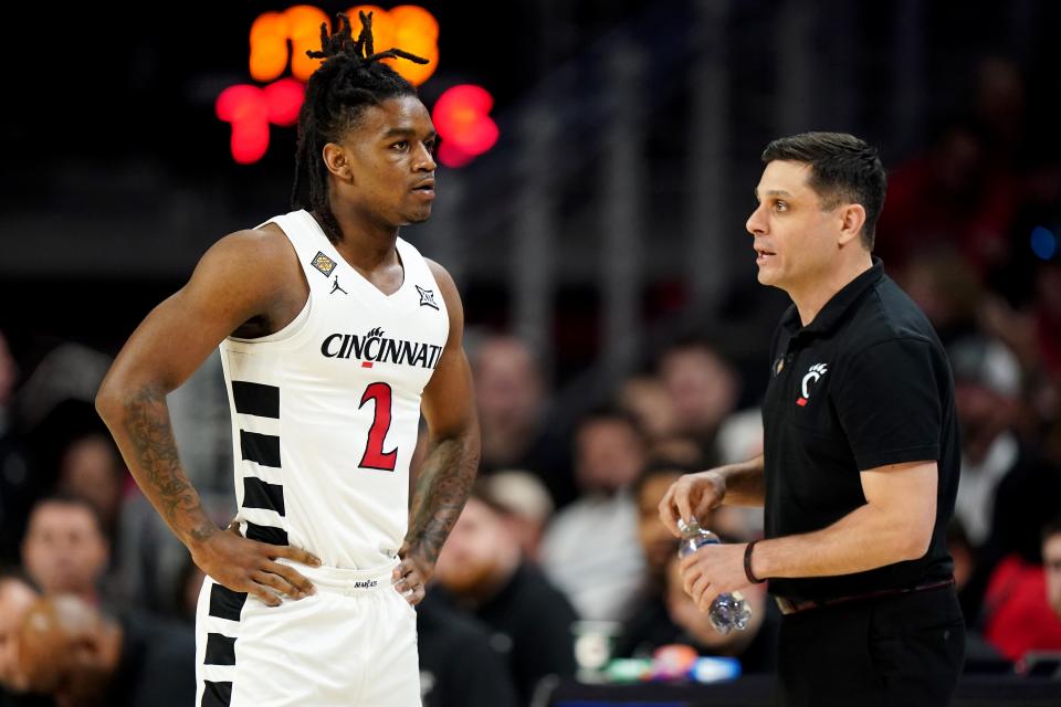 Cincinnati Bearcats head coach Wes Miller, right, talks with Cincinnati Bearcats guard Jizzle James (2) in the first half of a college basketball game against the Bradley Braves during a second-round game of the National Invitation Tournament,, Saturday, March 23, 2024, at Fifth Third Arena in Cincinnati.