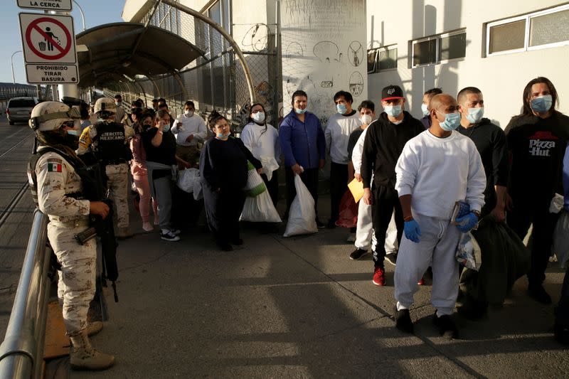 Mexican immigrants wait outside of a National Institute of Migration (INM) building after being deported from the United States and crossing the Paso del Norte border bridge amid the spread of the coronavirus disease (COVID-19), in Ciudad Juarez