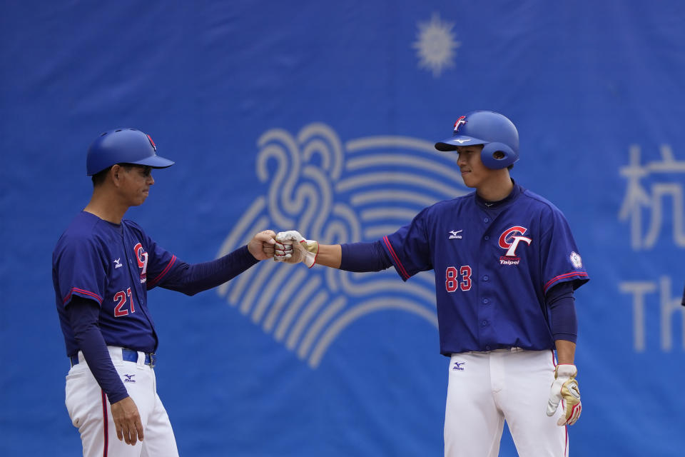 Taiwan's Lin Li at right bumps fist with another teammate during stage group round B Baseball Men game against Hong Kong for the 19th Asian Games in Hangzhou, China on Tuesday, Oct. 3, 2023. At the Asian Games China has been going out of its way to be welcoming to the Taiwanese athletes, as it pursues a two-pronged strategy with the goal of taking over the island, which involves both wooing its people while threatening it militarily. (AP Photo/Ng Han Guan)