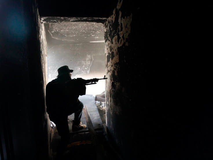 A fighter of Libyan forces allied with the U.N.-backed government aims his weapon as he takes up position inside a ruined house at the front line of fighting with Islamic State militants in Ghiza Bahriya district in Sirte, Libya November 9, 2016. REUTERS/Ismail Zitouny