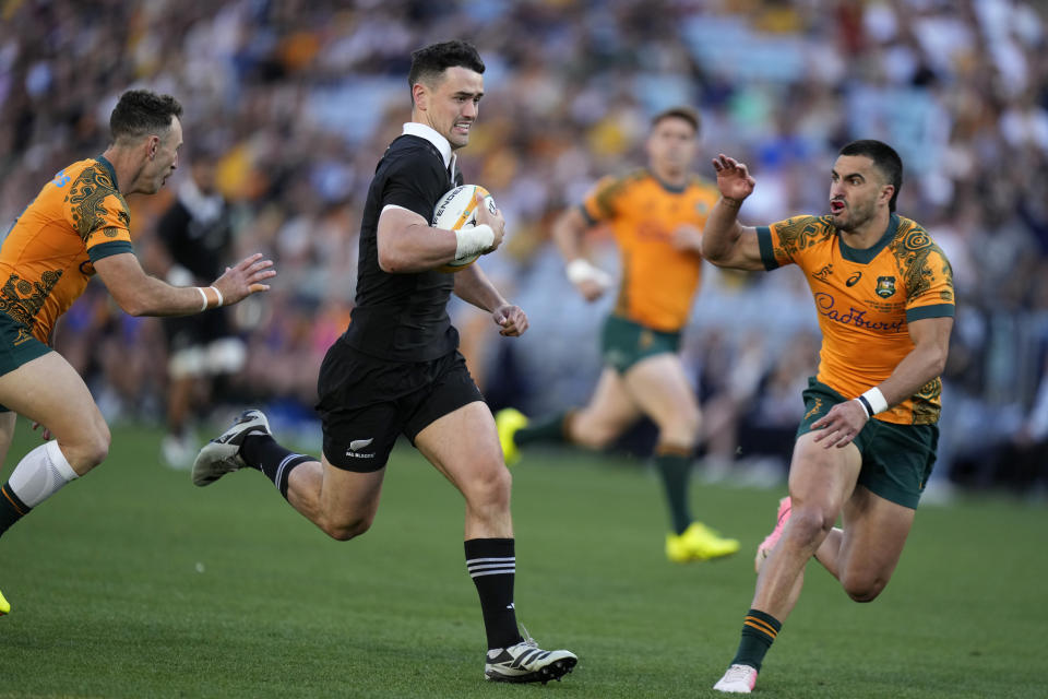 New Zealand's Will Jordan, center, races past Australia's Nic White, left, and Tom Wright to score a try during their rugby union test match in Sydney, Saturday, Sept. 21, 2024. (AP Photo/Rick Rycroft)