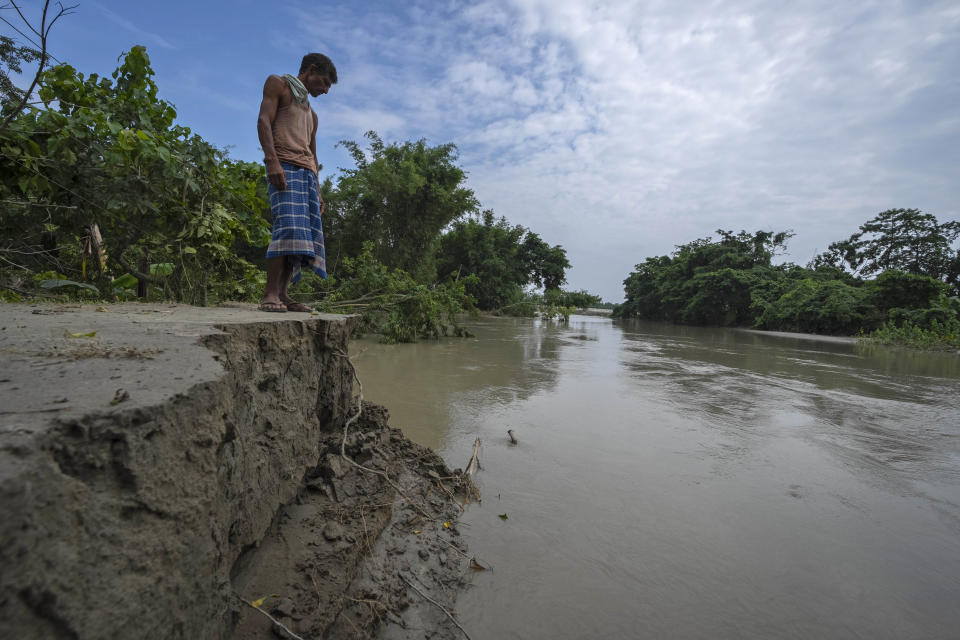 A villager looks at a damaged embankment near Puthimari river in Bali village, west of Guwahati, India, Friday, June 23, 2023. Tens of thousands of people have moved to relief camps with one person swept to death by flood waters caused by heavy monsoon rains battering swathes of villages in India’s remote northeast this week, a government relief agency said on Friday. (AP Photo/Anupam Nath)