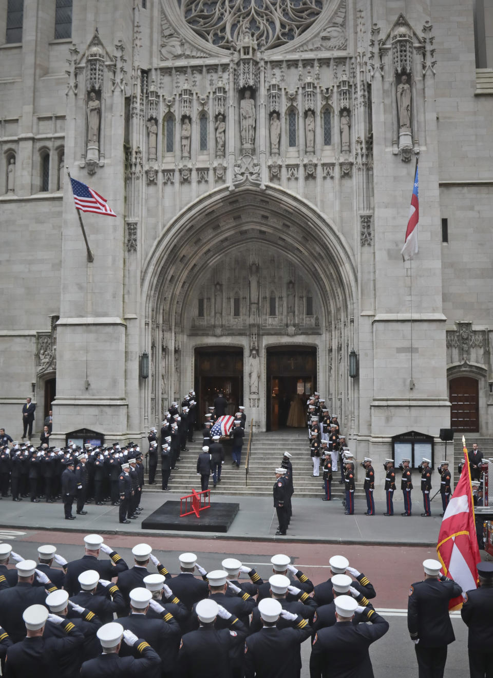 The casket of U.S. Marine Corps Staff Sergeant and FDNY Firefighter Christopher Slutman, center, arrives for his funeral service at St. Thomas Episcopal Church, Friday April 26, 2019, in New York. The father of three died April 8 near Bagram Airfield U.S military base in Afghanistan. (AP Photo/Bebeto Matthews)