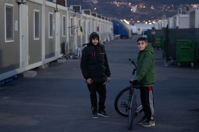 Two boys play between container homes near Kahramanmaras, where they and their families were housed after the 7.8-magnitude earthquake that struck southern Turkey and northern Syria on 06 February 2023. Boris Roessler/dpa