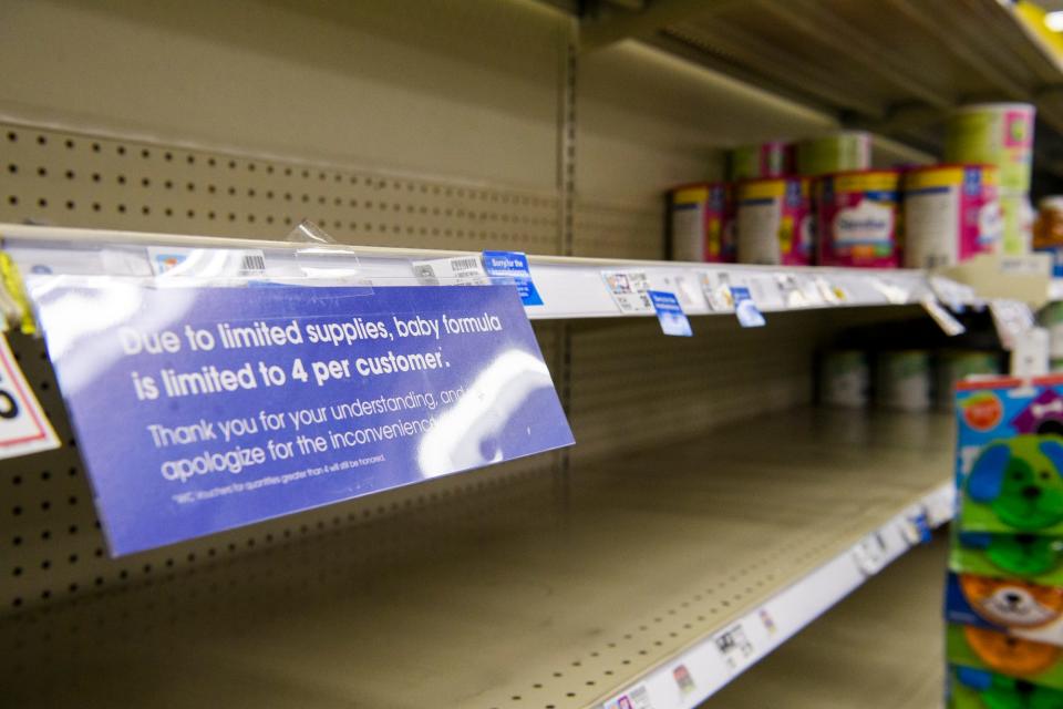 Empty shelves surround a sign explaining to customers why they are limited to four baby formula products per visit at Kroger.