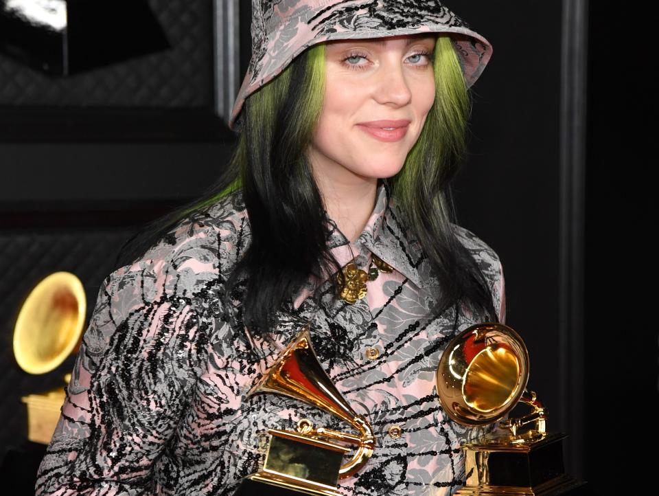 Billie Eilish posing with her two awards at the 2021 Grammys.