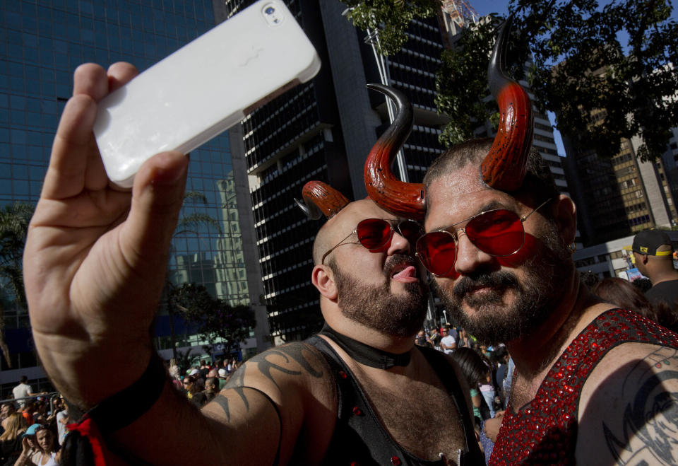 Revelers take a selfie during the annual Gay Pride Parade in Sao Paulo, Brazil, Sunday, May 4, 2014. Gay rights advocates are calling for a Brazilian law against discrimination as they gather by the hundreds of thousands in Sao Paulo for one of the world's largest gay pride parades. (AP Photo/Andre Penner)