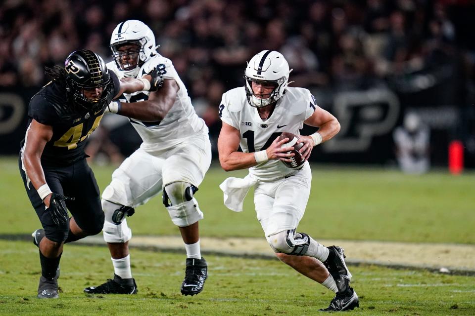 Penn State quarterback Sean Clifford (14) scrambles against Purdue during the first half of an NCAA college football game in West Lafayette, Ind., Thursday, Sept. 1, 2022. (AP Photo/Michael Conroy)