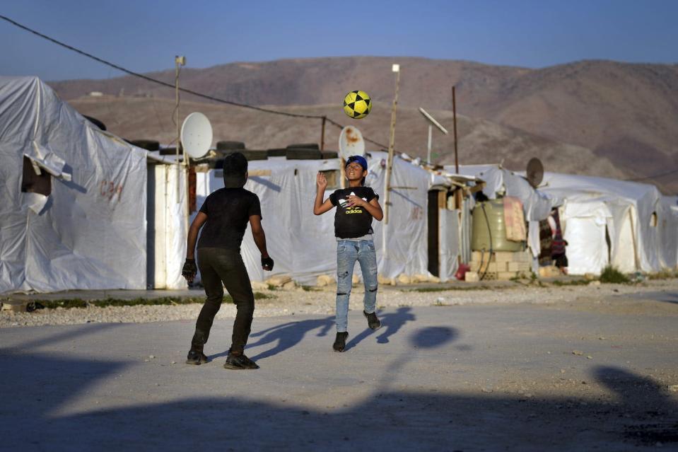 Syrian children play soccer near their tented homes at a refugee camp in the town of Bar Elias in Lebanon in July 2022. (AP Photo/Bilal Hussein)