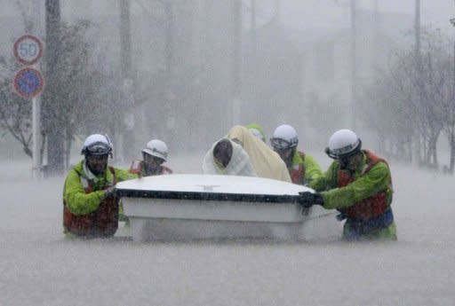 Rescue workers transport evacuees in a boat through floodwaters in Nagoya, Aichi prefecture, in central Japan. More than a million people in Japan were warned to leave their homes on Tuesday as an approaching typhoon brought heavy rain and floods which left three dead or missing