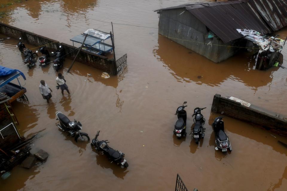 People wade along a waterlogged road after heavy rains following Cyclone Nivar landfall, in Puducherry on November 26, 2020. (Photo by Arun SANKAR / AFP) (Photo by ARUN SANKAR/AFP via Getty Images)