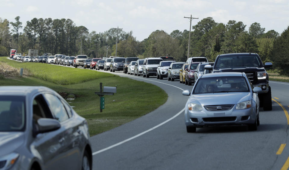 People sit in a long line of bumper to bumper traffic on US 421 in Harrells, N.C., Wednesday, Sept. 19, 2018 as they try to make their way toward Wilmington, N.C. (AP Photo/Chuck Burton)