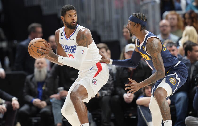 Los Angeles Clippers forward Paul George, left, looks to pass the ball as Denver Nuggets guard Kentavious Caldwell-Pope.