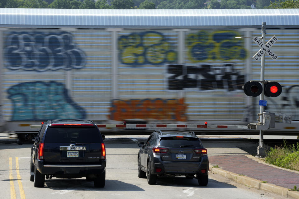 A CSX freight train rolls through a crossing in Homestead, Pa., Sunday, June 18, 2023. Spurred on by train derailments, some states with busy criss-crossing freight railroads are pursuing their own safety remedies rather than wait for federal action amid industry opposition and questions about whether they even have authority to make the changes. (AP Photo/Gene J. Puskar)