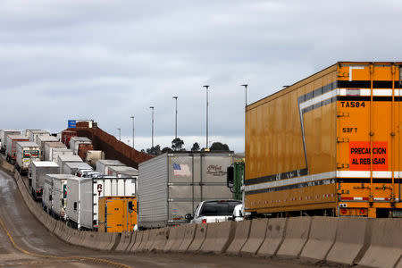 Trucks wait in a long queue at border customs control to cross into the U.S, caused by the redeployment of border officers to deal with a surge in migrants, at the Otay border crossing in Tijuana, Mexico April 3, 2019. REUTERS/Carlos Jasso