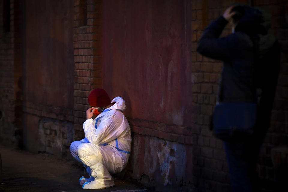 An emergency paramedic leans against a wall outside the Matei Bals hospital compound in Bucharest, Romania, Friday, Jan. 29, 2021. A fire early Friday at a key hospital in Bucharest that also treats COVID-19 patients killed four people, authorities said. (AP Photo/Andreea Alexandru)