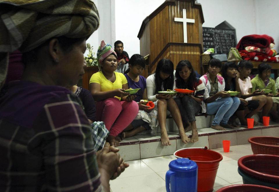 Villagers pray before taking their dinner inside a church used as temporary shelter. The National Disaster Mitigation Agency announced that the status of Mount Sinabung had been raised from "caution" to "alert" due to an increase in volcanic activities, local media reported. (Reuters)