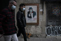 People walk past a poster that reads 'I want you to stay home', by artist TvBoy amid a lockdown in Barcelona, Spain, Tuesday, March 24, 2020. More than 1.5 billion around the world have been told to stay in their homes. For most people, the new coronavirus causes only mild or moderate symptoms. For some it can cause a more serious illness. (AP Photo/Felipe Dana)
