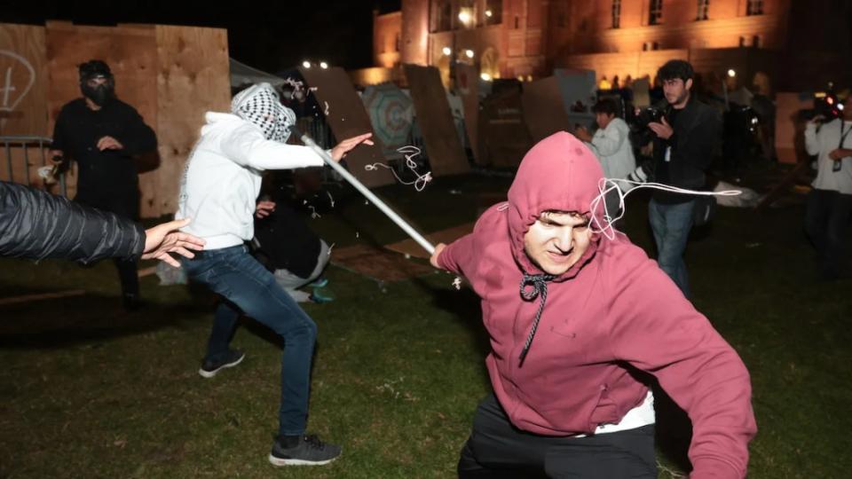 A Pro-Palestinian protestor clashes with a pro-Israeli supporter at an encampment at UCLA on April 30
