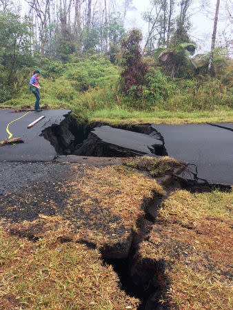 A geologist inspects cracks on a road in Leilani Estates, following eruption of Kilauea volcano, Hawaii May 17, 2018. United States Geological Survey (USGS)/Handout via REUTERS