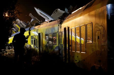 A rescuer works at the site where two passenger trains collided in the middle of an olive grove in the southern village of Corato, near Bari, Italy, July 12, 2016. REUTERS/Alessandro Garofalo