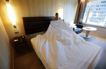 A chambermaid who works at a hotel where chambermaids are members of staff and not associated with the "Kellys" association, makes a bed in Madrid, Spain, July 26, 2018. Picture taken July 26, 2018. REUTERS/Paul Hanna