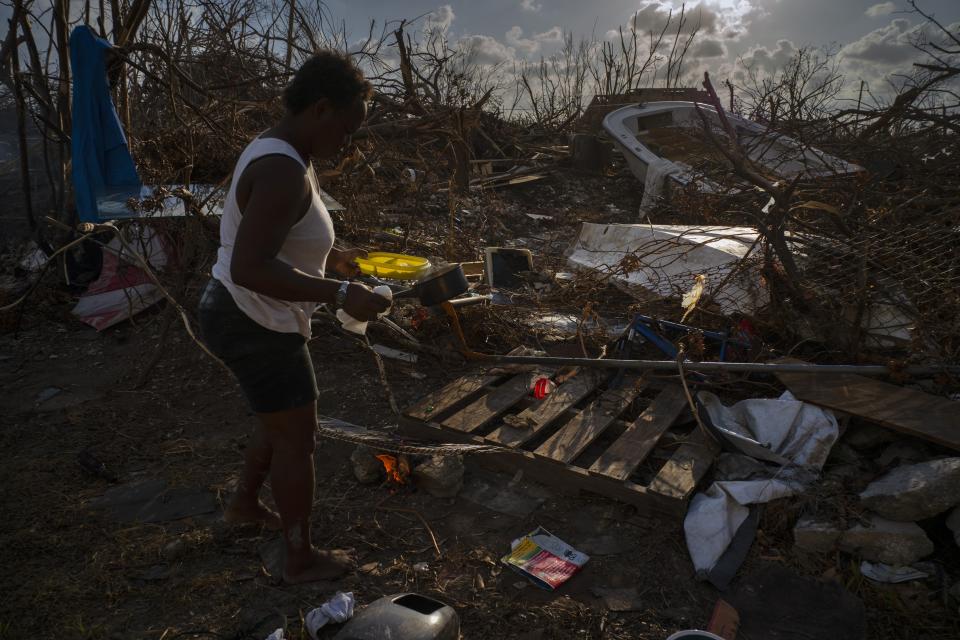 Tereha Davis, 45, holds a plate of rice as she walks among the remains of her shattered belongings, in the aftermath of Hurricane Dorian, in McLean’s Town, Grand Bahama, Bahamas, Wednesday Sept. 11, 2019. She and others said they had not seen any government officials and have only received food and water from some nonprofit organizations. (AP Photo/Ramon Espinosa)